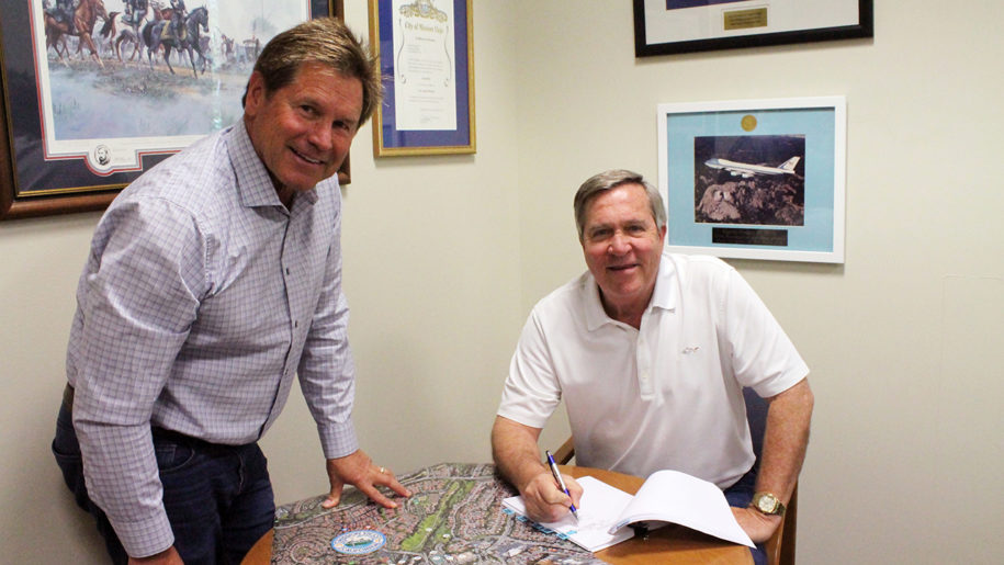 mayor greg raths and brian goodell signing papers